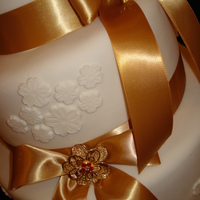 Gold Bows 6''-9''-12'' covered in white fondant, with gold bows and brooches.