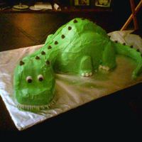 Green Dino Dino for a Birthday... made from round cakes cut in half for body & head, tail & neck are RKT.. covered in BC