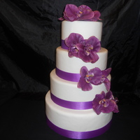 Purple Wedding Cake all covered in fondant artificial flowers.