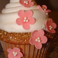 Pink Blossoms Jumbo Cupcake Baked with the Wilton jumbo pan. I rolled the edge of the cupcake in gold sprinkles first. Topped with buttercream and gumpaste flowers.