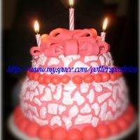 Pink Leopard moms birthday cake, pink fondant with free handed strawberry icing leopard spots and a pink fondant gift bow on top