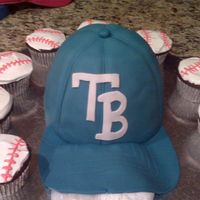 Baseball Cake Cake was made for my nephew. Chocolate cake with fresh strawberry filling. Cake is covered in fondant. Cupcakes are covered with vanilla...