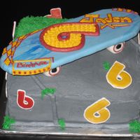Skateboard Cake Fondant skateboard with royal icing logos buttercream cake for sidewalk and grass.