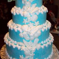 By The Shore Wedding cake with sea blue buttercream icing. Molded white chocolate sea shells.