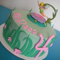 Tinkerbell Simple tinkerbell cake. Scratch WASC with raspberry whip cream filling, covered in SMBC with satin ice accents....