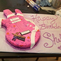 Hannah Montana Guitar Cake This was a Hannah Montana Guitar Cake that we carved and made. Fondant is homemade and the scrolling is custom painted. The logo was also...