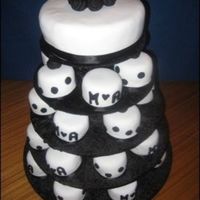 Black And White Engagment Cakes 30 mini mud cakes covered in fondant with black accents. Rolled Roses on top of large cake. Couples initals on smaller cakes.