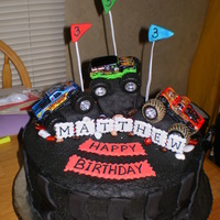 Monster Truck Tire Mud tire, with monster truck toys.. Buttercream frosting, decorations withfondant. Chocolate cake.