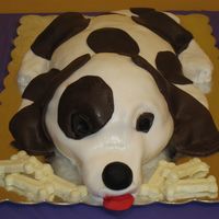 Dog Cake I used the wilton soccer ball for the head, football pan for the body, paws molded from RKT, covered in satin ice with white chocolate dog...