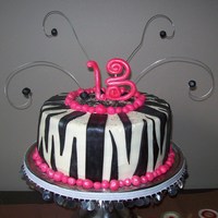 Hot Pink And Black Zebra Striped Cake Done for a 13 year old. Iced with buttercream and decorated with fondant accents.