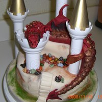 Dragon And Castle Dragon is made out of fondant and draped onto the cake!