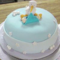 Baby Stork Watching Over A Baby 6" round with pastel blue fondant with a fondant cloud border and fondant stars and bubbles covered with silver luster dust topped...
