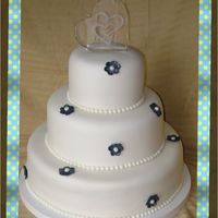 White 3 Tier Wedding Cake White 3 tier wedding cake with blue pearl dusted flowers.