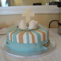 Baptism Cake Covered in fondant with fondant baby booties and white chocolate cross.