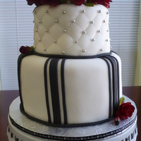 Black And White Wedding Cake Cake is french vanilla with buttercream icing and covered with fondant. Accents and roses are fondant/gumpaste. TFL!
