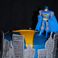 Batman 9" covered with buttercream. Colorflow buildings, and fondant searchlight. Got the idea from another cc'er