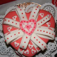 Valentine Cake Yellow cake with icing...then covered with fondant and fondant hearts all over. Had a a bit of trouble with the bow...this is my second...
