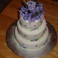 60Th Birthday Cake fonant covered cake with small fondant and royal icing flowers. The flowers on top are silk.