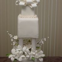 Wedding Cake This is a fondant covered cake with gumpaste flowers and bow on top.