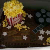Going To The Movies Was a movie theme birthday cake, for a clients daughters birthday. Cake is chocolate with chocolate butter-cream frosting. Popcorn is...