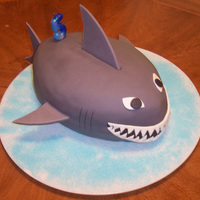 Shark Cake Made this cake for my son's 5th birthday. Used the Wilton footbal pan, rolled fondant with gumpaste added for the fins, rolled fondant...