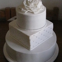 White Wedding - With Bling Dark chocolate, white chocolate and caramel mudcakes covered in white fondant. Swarovsky crystals added as bling. Large rose topper made...