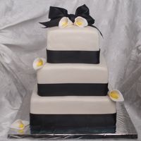 Lilies And Black Ribbon WASC with IMBC and fondant overlay. Black satin ribbon and gumpaste lilies. 6", 8", and 10" square tiered. I also made a 12...