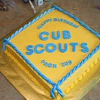 Cub Scouts Gold Buttercream with blue fondant lettering and rope.