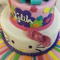 Hellooooo . . . Kitty! 3 Tiered Birthday cake finished with fondant stripes, flowers and bow. Hand painted Hello Kitty Face and sparkle bow.