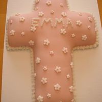 Girl's Baptism Or First Communion Cake Made with Wilton's cross shaped pan and covered in pink fondant with white fondant flowers.