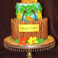 Tropical Bliss Two tier 12" & 7" tropical themed cake covered with pirogee cookies for the fence, iced in buttercream for a new baby. The...