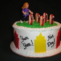 Hot Dog! It's Your Birthday Birthday cake for a hot dog lover. Fondant figures and ketchup/mustard bottles on buttercream cake.