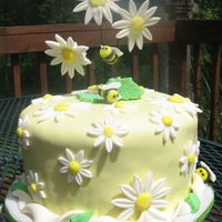 Daisies And Bees Cake covered in fondant. Flowers and bees made with gumpaste.