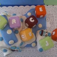 Baby Blocks Its vanilla cake, made the blocks out of Rice Crispy Treats. And the dots are Chocolate.