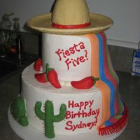 Fiesta Five Birthday Cake 10" and 6" rounds with mini wonder mold cake in sombrero, covered in BC. Fondant blanket, sombrero, peppers, cacti.