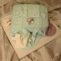 Diaper Bag A diaper bag with accessories. Inside is heavenly white cake with orange mousse, iced with orange buttercream and covered with fondant.
