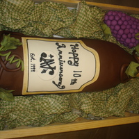 Wine Bottle Red velvet cake wine bottle covered in chocolate fondant with rice crispie grapes fondant leaves and accents