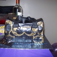 My 1St Coach Bag 1/4 sheet cake cut into 3rds stacked and craved into bag shape.. yellow cake on the inside covered with black stain fondant ... TFL