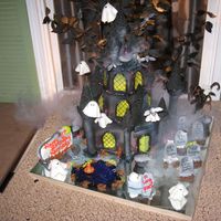 Haunted Castle I made this for my neice's birthday. I used wiltons castle kit and my imagination. Hanging ghost and bats from the top, graveyard...