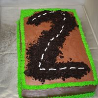 Motorcycle Cake Chocolate cake with chocolate buttercream filling and icing. The 2 is crushed oreos. The customer added motorcycles