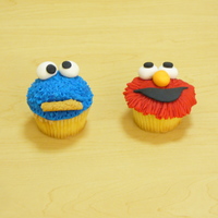 Elmo And Cookie Monster Cupcakes fondant covered cupcakes. The Fur on cookis monster was done pulling up and out on the fondant such that the fondant would stand out like...