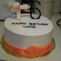 Karate Kid 6th birthday cake for my friend's son, who is an orange belt in karate. Buttercream iced, with fondant figure and accents.