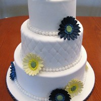 Gerbera Daisy Wedding Cake Navy blue and pale yellow sugarpaste gerbera daisies to match the bride's flowers. Handmade sugar pearls and quilting on the middle...