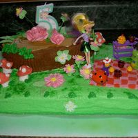 Tinkerbell Birthday Woodland Tea Party with the use of toy tinkerbell doll and cart set, a woodland scene is created using sugar art flowers, mushrooms, blanket, & leaves....