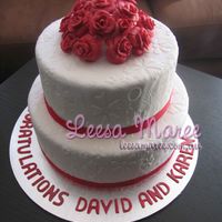 Two Tier White Fondant Cake With Roses Two tier embossed fondant cake. Bottom layer is white chocolate mud cake and top is caramel mud cake.Used an embossing mat on the fondant,...