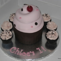 Giant Cupcake Cake Giant cupcake cake (carved from 4 6" cakes) with a cherry candle on top. 12 regular cupcakes to match.