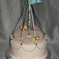 Circus Carousel buttercream cake with fondant accents. The animals are paper (from a kit the client bought).