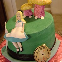 Alice In Wonderland Buttercream topsy Mad Hatter's hat w/ gumpaste Alice, watch, and flowers. Mushrooms are fondant covered rice krispie treats.