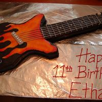 Guitar Buttercream with fondants accents: dials, pegs at top, and string holder thing in the middle. Sorry I don't know the proper names of...