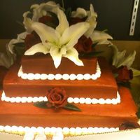 Red Buttercreme Wedding Cake i used white cake iced with brill red buttercream icing topper is fresh oriental lilies and madame roses